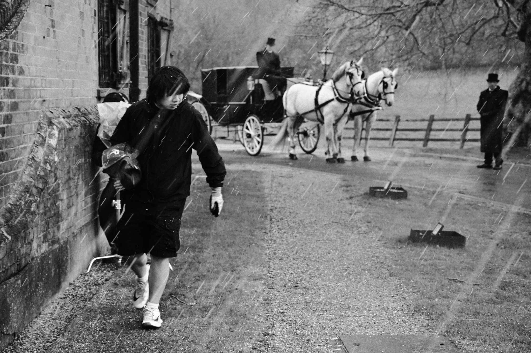 Crew member working beside a period horse carriage in the snow